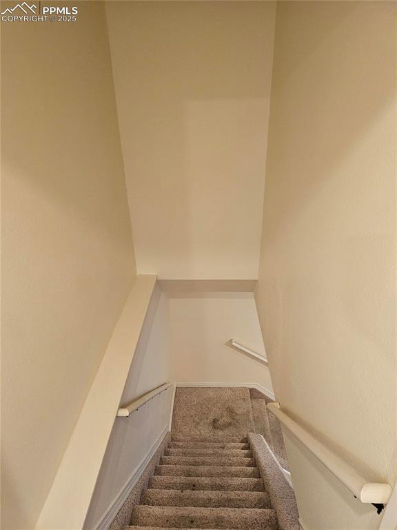 stairs featuring carpet flooring and baseboards