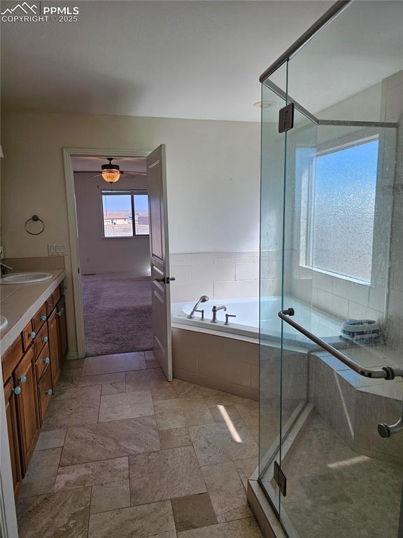 full bath featuring a garden tub, a ceiling fan, a sink, and a stall shower