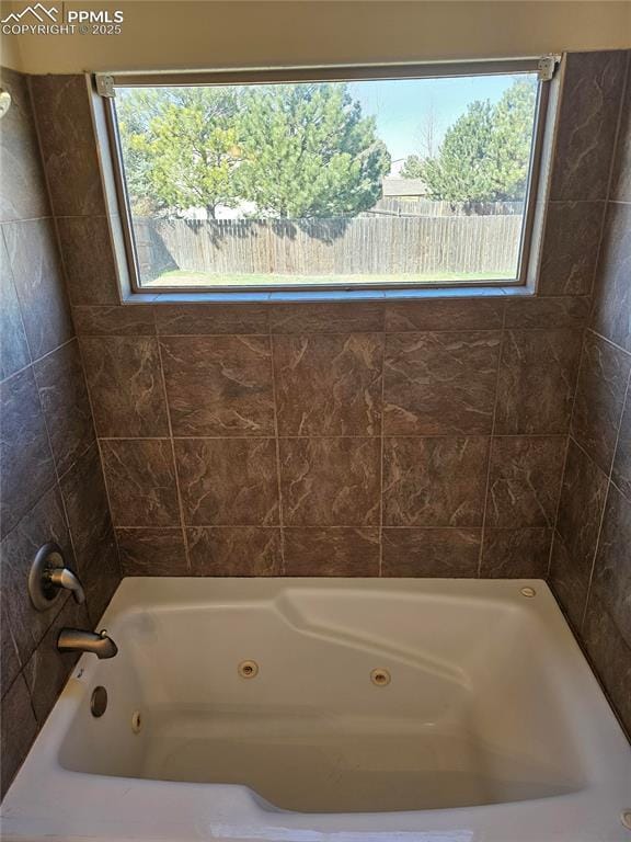 bathroom with plenty of natural light and a combined bath / shower with jetted tub