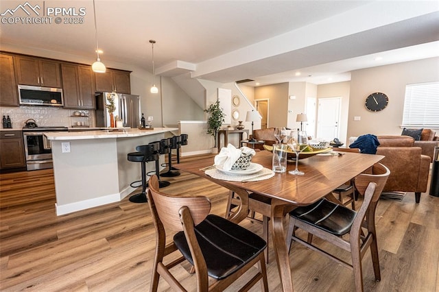 dining room featuring light wood-style floors, baseboards, and recessed lighting