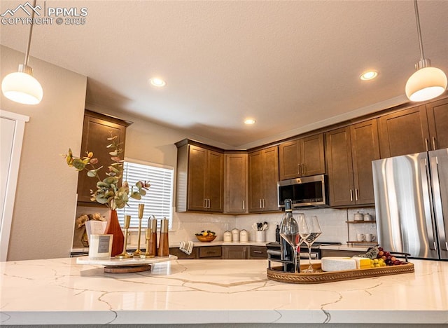 kitchen featuring appliances with stainless steel finishes, recessed lighting, light stone counters, and backsplash