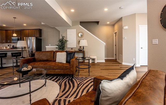 living room with light wood-type flooring, recessed lighting, and baseboards