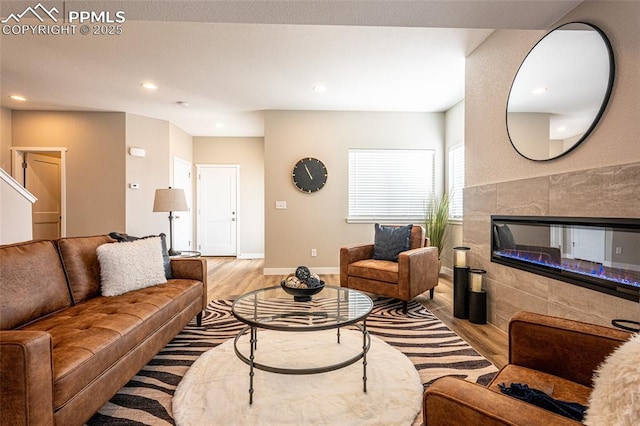 living area featuring wood finished floors, recessed lighting, a fireplace, and baseboards