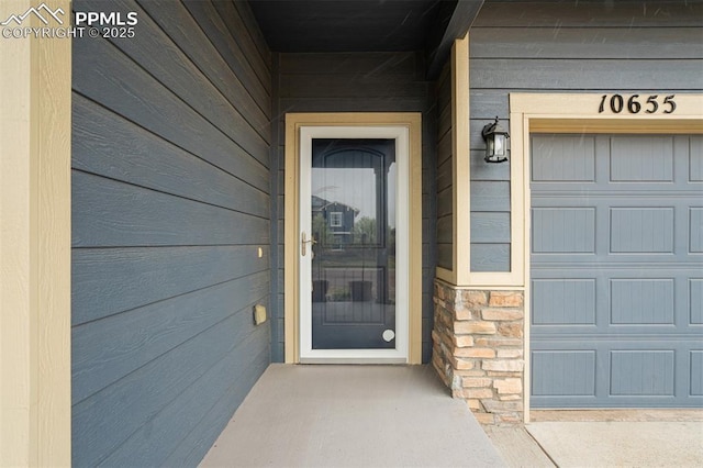 entrance to property with stone siding and a garage
