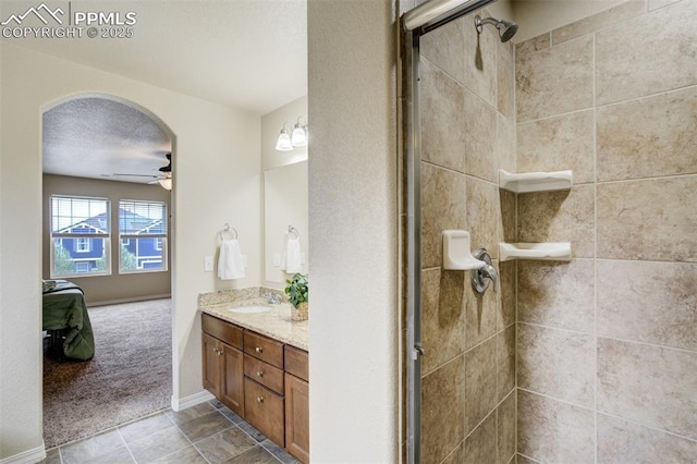 ensuite bathroom featuring ensuite bath, vanity, ceiling fan, and tiled shower