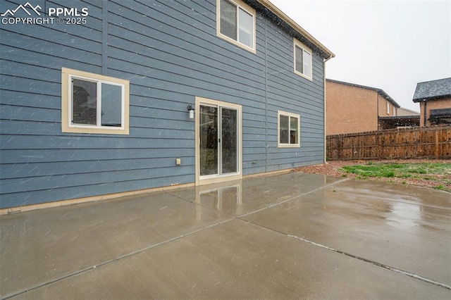 rear view of house with a patio area and fence
