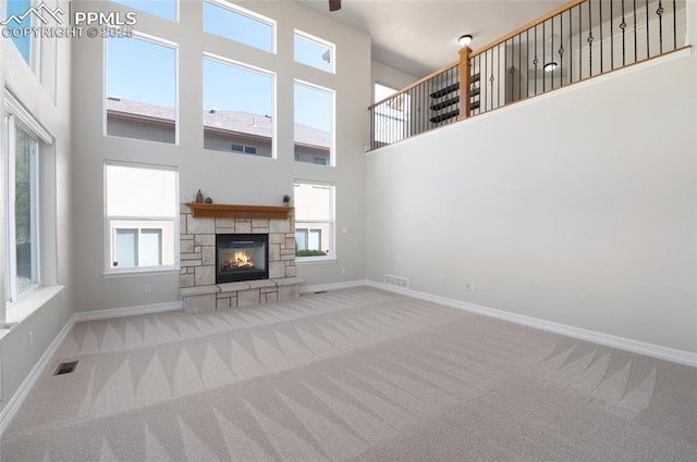 7436 Centennial Glen Dr, Colorado Springs, CO 80919 - unfurnished living room featuring baseboards, visible vents, carpet, and a towering ceiling