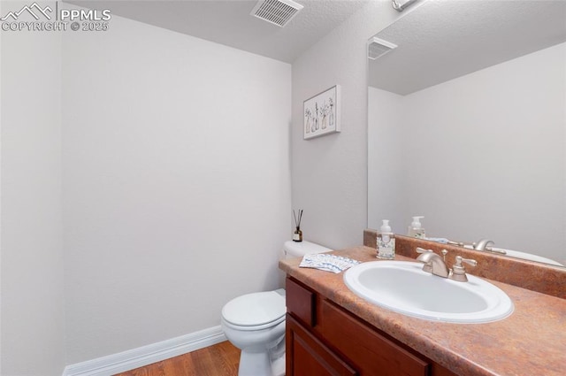7436 Centennial Glen Dr, Colorado Springs, CO 80919 - bathroom featuring vanity, toilet, baseboards, wood finished floors, and visible vents