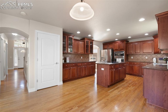 7436 Centennial Glen Dr, Colorado Springs, CO 80919 - kitchen featuring arched walkways, a sink, dark countertops, and stainless steel appliances