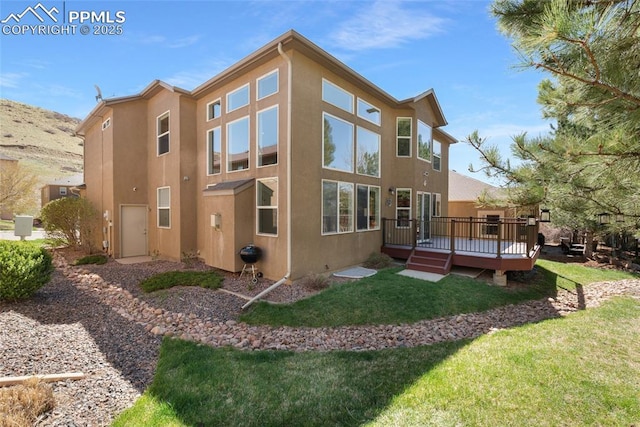 7436 Centennial Glen Dr, Colorado Springs, CO 80919 - back of house featuring a lawn, a wooden deck, and stucco siding