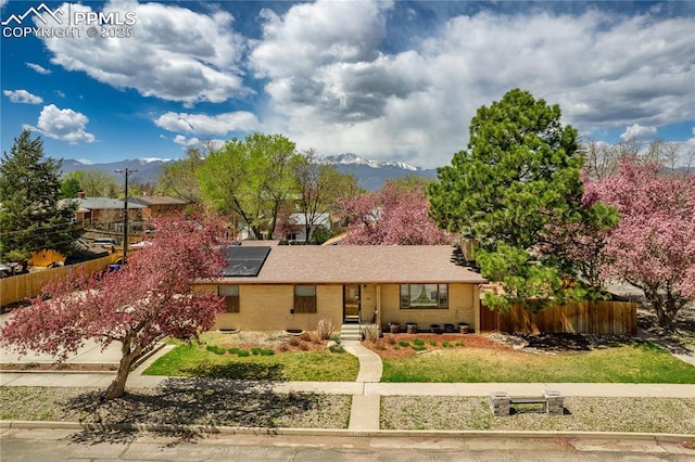 1514 Howard Ave, Colorado Springs, CO 80909 - ranch-style home with fence, a mountain view, and solar panels
