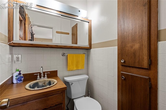 1514 Howard Ave, Colorado Springs, CO 80909 - bathroom with tile walls, toilet, and vanity