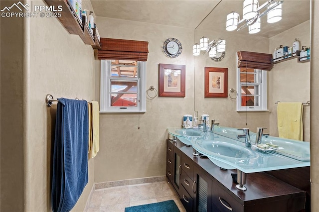 1514 Howard Ave, Colorado Springs, CO 80909 - bathroom with baseboards, tile patterned flooring, a sink, and double vanity