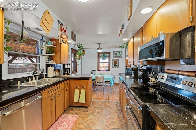 1514 Howard Ave, Colorado Springs, CO 80909 - kitchen with brown cabinets, a ceiling fan, stainless steel appliances, and a sink