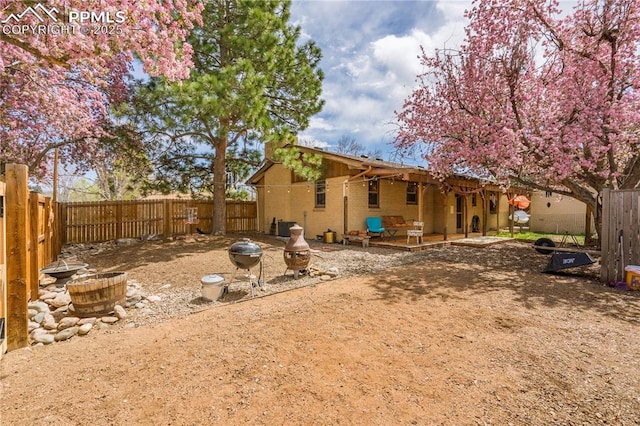 1514 Howard Ave, Colorado Springs, CO 80909 - rear view of property featuring brick siding, a patio, and a fenced backyard