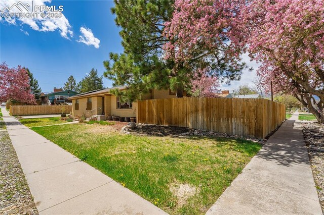 1514 Howard Ave, Colorado Springs, CO 80909 - view of side of home with a lawn and fence