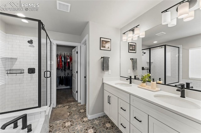 full bath featuring double vanity, a sink, and a shower stall