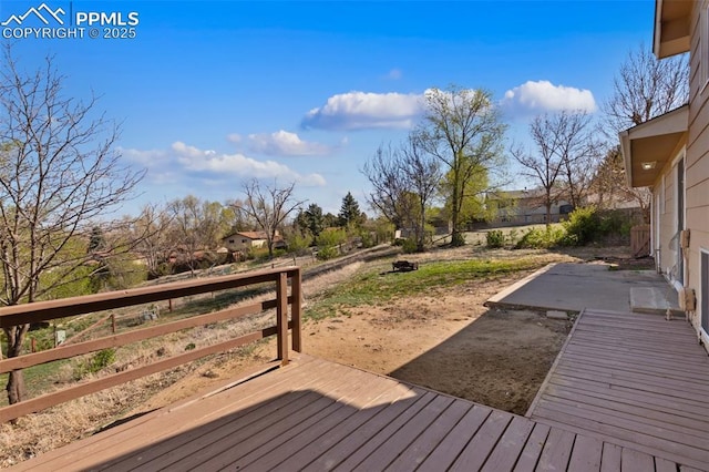 wooden deck with fence and a patio area