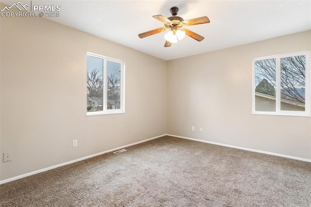 empty room featuring ceiling fan, baseboards, visible vents, and carpet