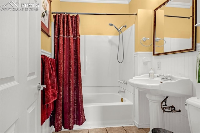 bathroom featuring toilet, shower / bath combo, wainscoting, and tile patterned floors