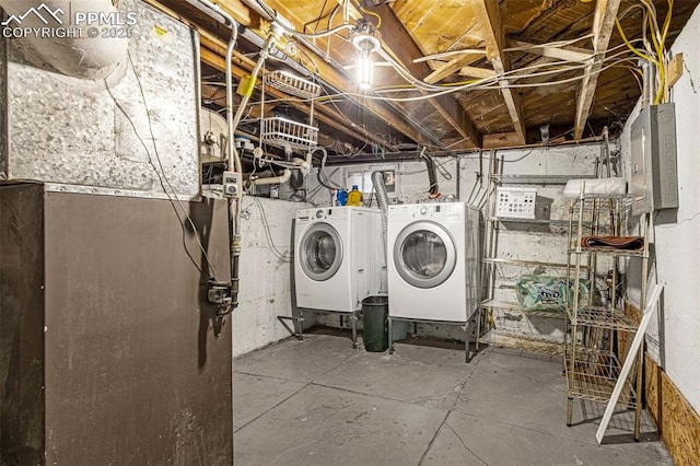 washroom featuring washing machine and clothes dryer, electric panel, and laundry area