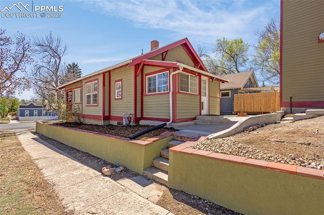 view of front of home with fence and a chimney
