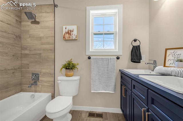 bathroom featuring a sink, double vanity, visible vents, baseboards, and toilet