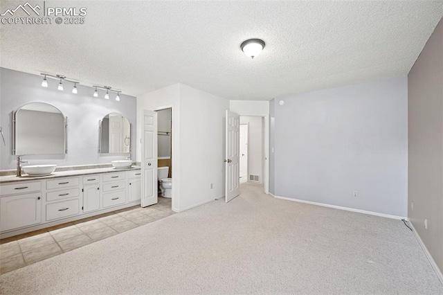 70 Palm Springs Dr, Colorado Springs, CO 80921 - full bath featuring double vanity, a textured ceiling, toilet, baseboards, and carpet