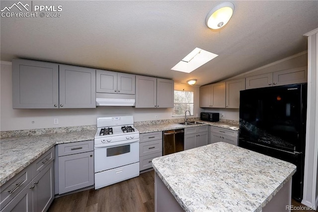 kitchen with gray cabinets, a sink, lofted ceiling with skylight, black appliances, and dark wood-style flooring