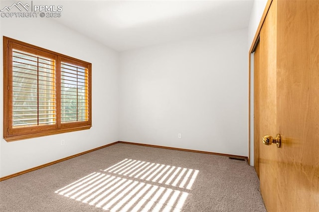 unfurnished bedroom with baseboards, carpet flooring, and a closet