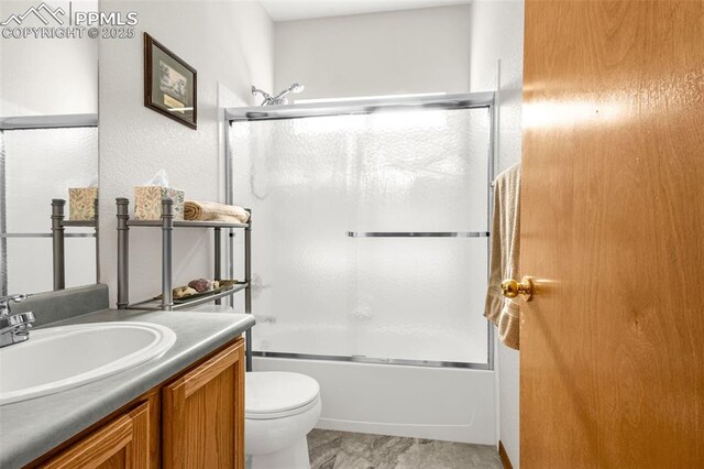 full bathroom featuring vanity, shower / bath combination with glass door, and toilet