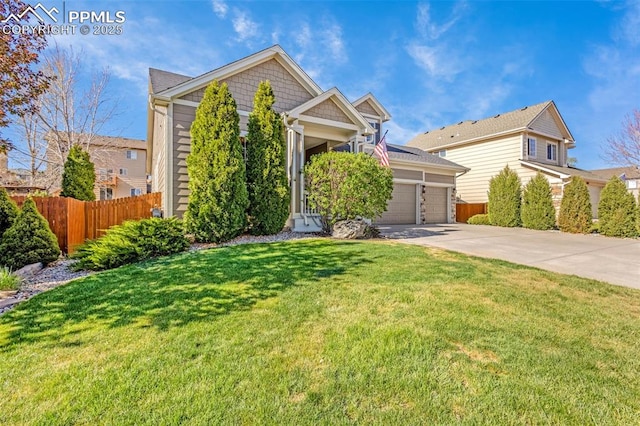 view of front of home with concrete driveway, an attached garage, fence, and a front yard