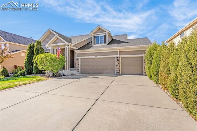 view of front of house with an attached garage, driveway, and stone siding
