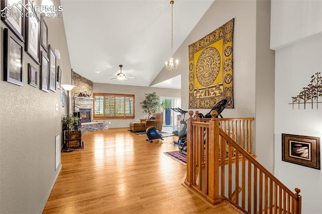 interior space with light wood-style floors, high vaulted ceiling, a notable chandelier, and an upstairs landing