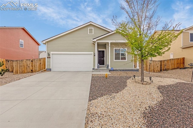 view of front of property with an attached garage, concrete driveway, and fence