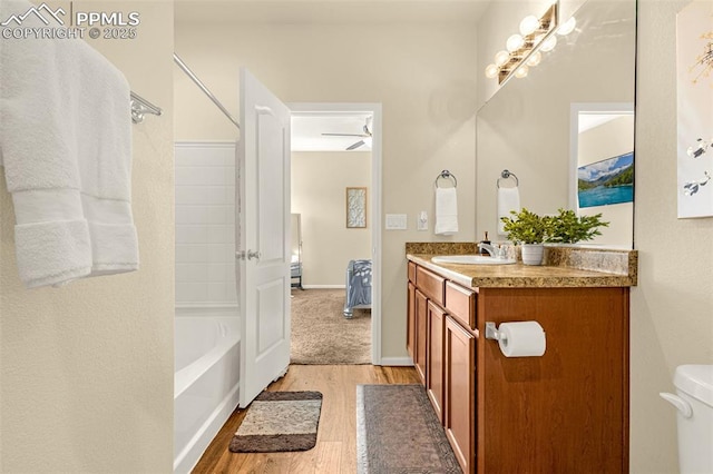 full bath with washtub / shower combination, wood finished floors, and vanity