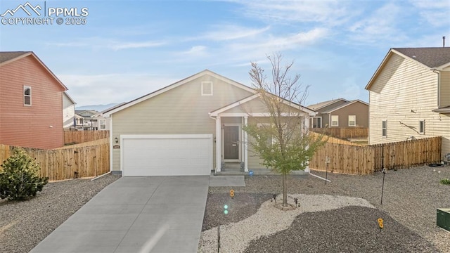 view of front of home with an attached garage, driveway, and fence