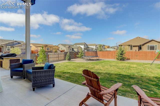 view of patio with a residential view, a fenced backyard, and a trampoline