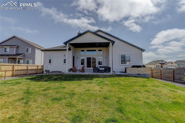 back of property with a fenced backyard, a patio area, stucco siding, and a yard