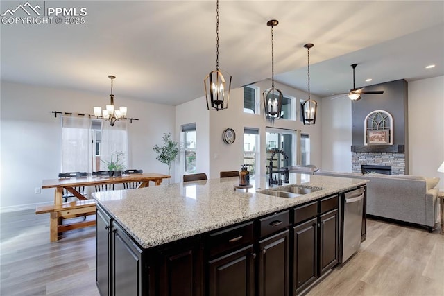 kitchen featuring a sink, a kitchen island with sink, light wood finished floors, and open floor plan