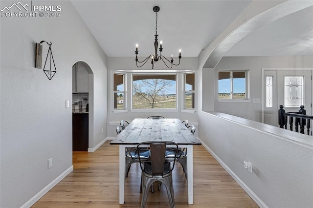 15930 Alta Plaza Cir, Peyton, CO 80831 - dining area with arched walkways, light wood finished floors, and a chandelier