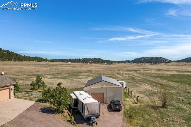 15930 Alta Plaza Cir, Peyton, CO 80831 - view of yard featuring an outdoor structure, a garage, a pole building, a rural view, and a mountain view