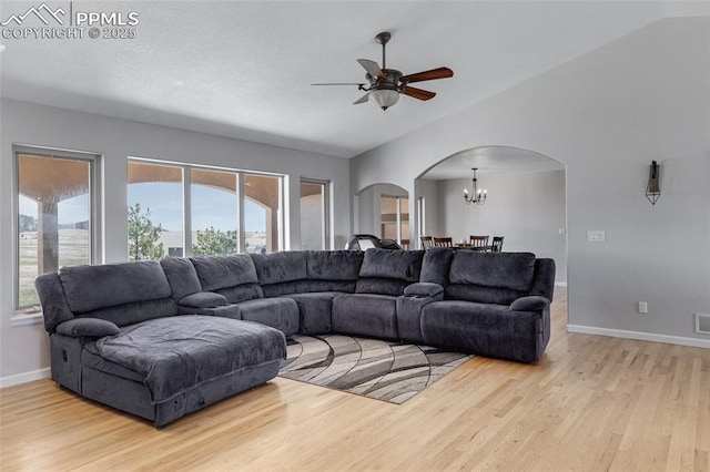 15930 Alta Plaza Cir, Peyton, CO 80831 - living room featuring arched walkways, a chandelier, wood finished floors, ceiling fan, and lofted ceiling