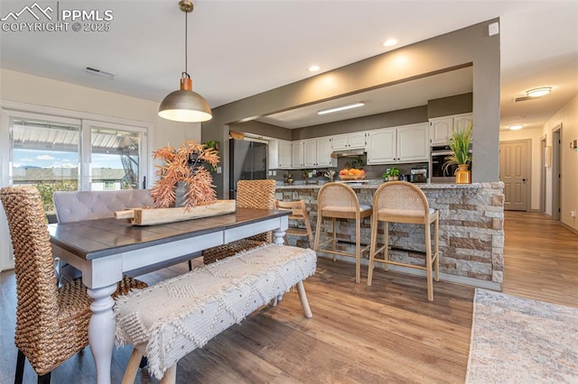 dining space featuring recessed lighting, visible vents, and light wood-type flooring