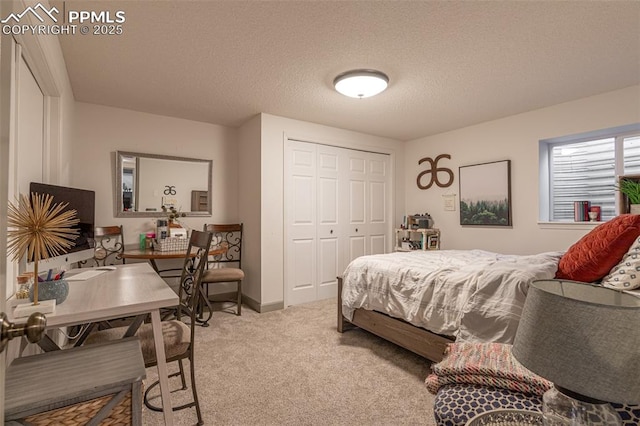 carpeted bedroom with a textured ceiling and a closet