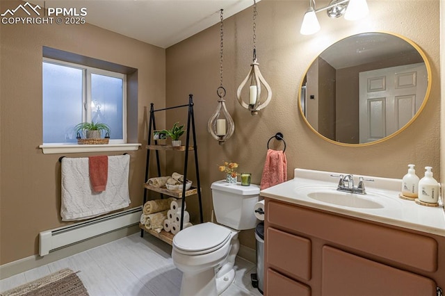 bathroom with a baseboard radiator, vanity, and toilet