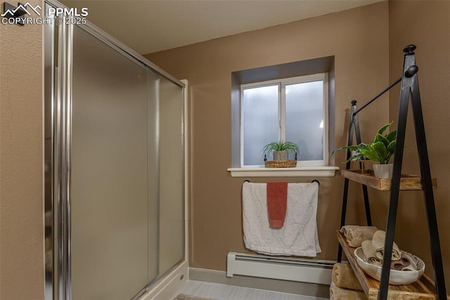 bathroom with baseboard heating, baseboards, and a shower stall