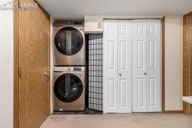 washroom with carpet floors, stacked washing maching and dryer, laundry area, and a textured ceiling