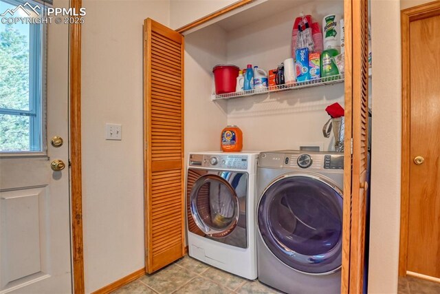 clothes washing area featuring washing machine and clothes dryer, tile patterned flooring, and laundry area