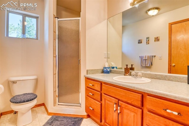 bathroom with a shower stall, toilet, vanity, baseboards, and tile patterned flooring